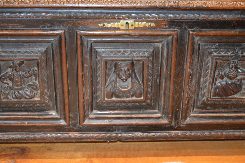 An 18th-century Flemish dark carved oak settle featuring figurative relief panels on the backrest and chest base with scrolled armrests. View III