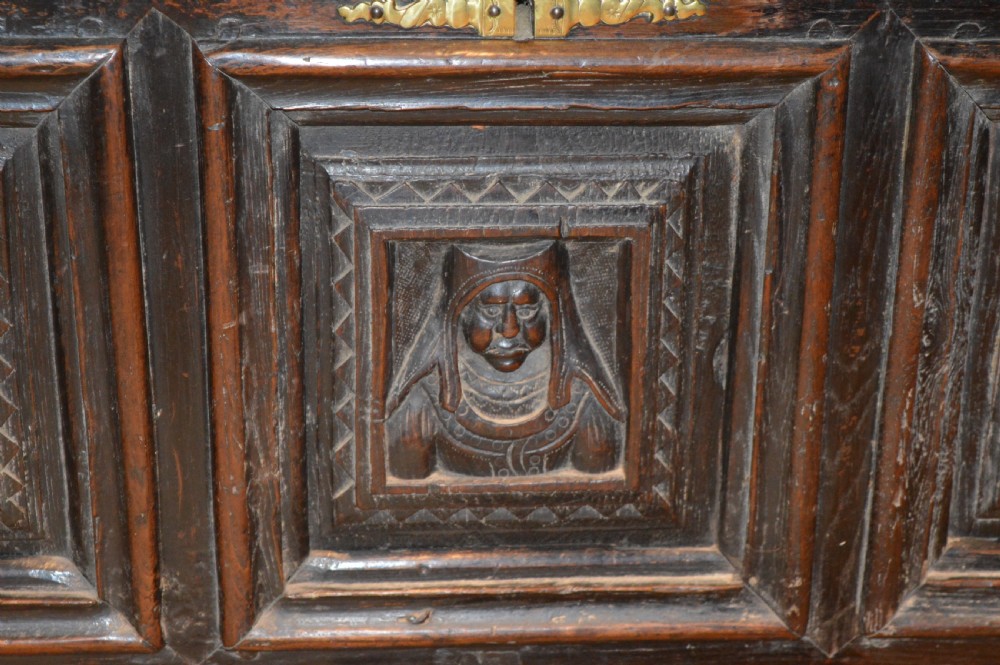An 18th-century Flemish dark carved oak settle featuring figurative relief panels on the backrest and chest base with scrolled armrests. View VIII
