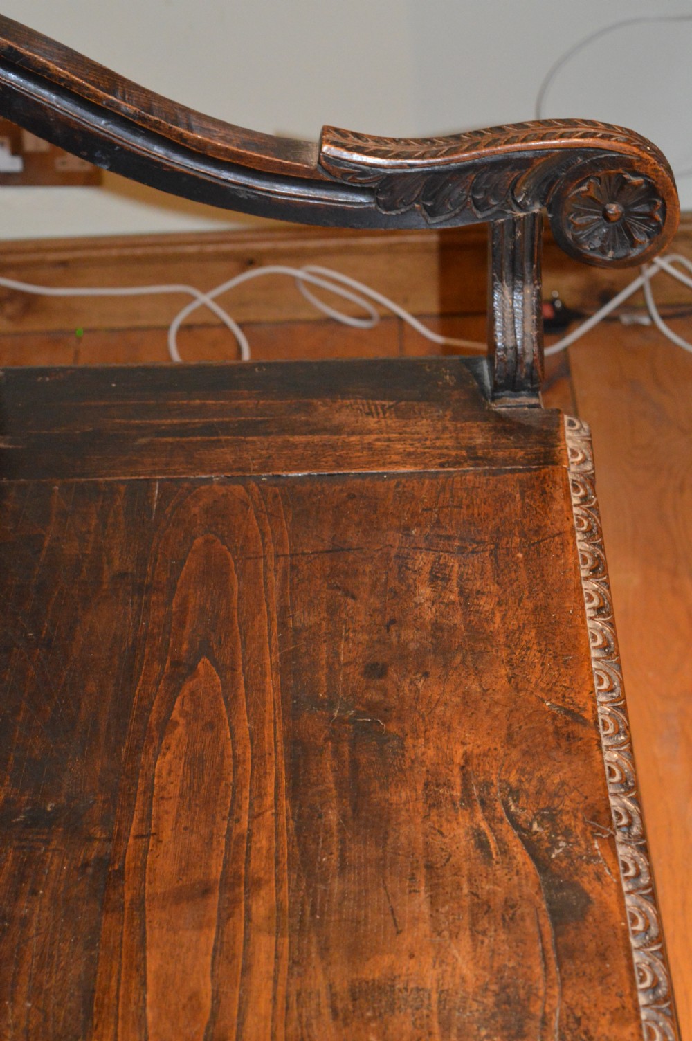 An 18th-century Flemish dark carved oak settle featuring figurative relief panels on the backrest and chest base with scrolled armrests. View XII