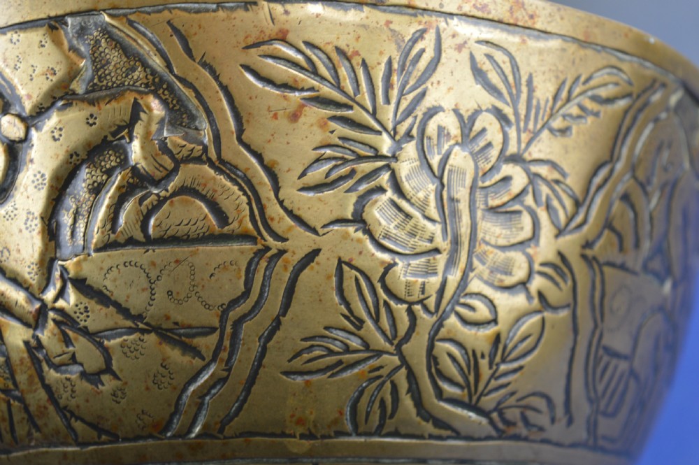 A large circular bronze bowl with relief engravings of figures in a landscape around the exterior and a polished interior. View VI