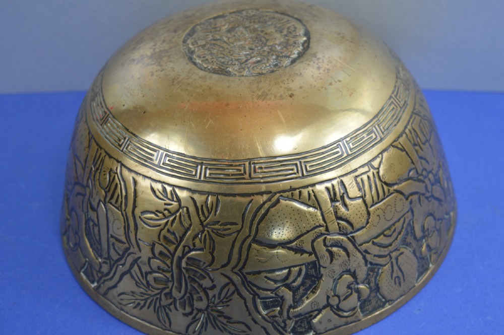 A large circular bronze bowl with relief engravings of figures in a landscape around the exterior and a polished interior. View VIII