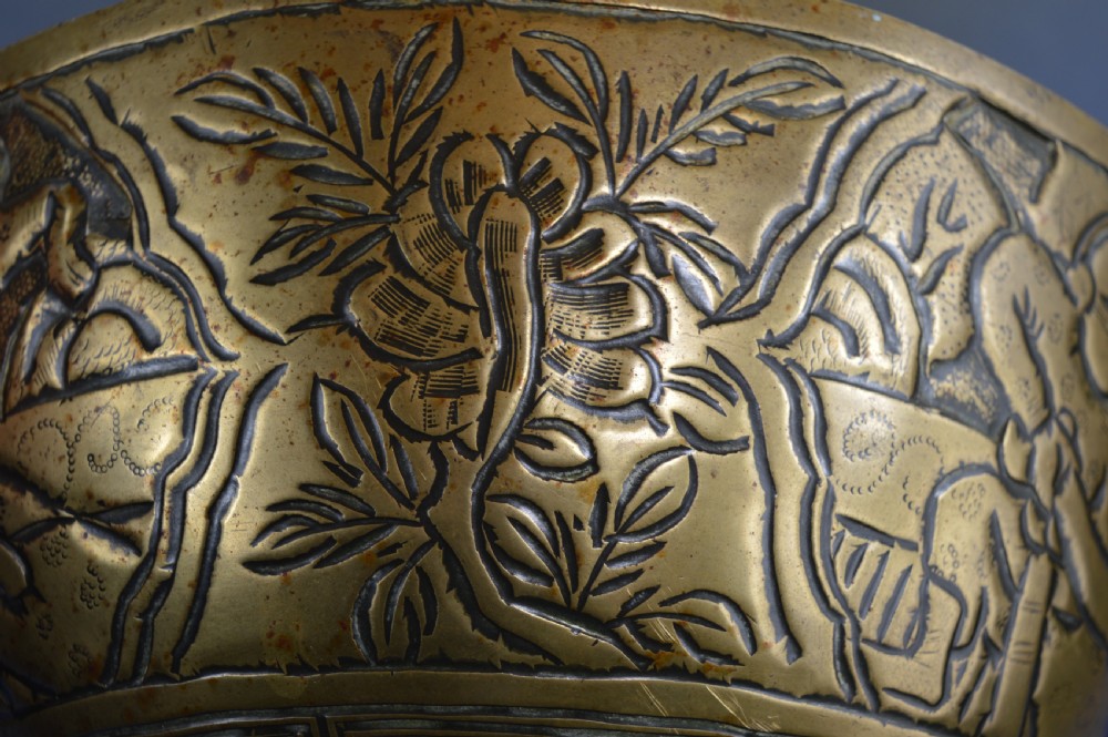 A large circular bronze bowl with relief engravings of figures in a landscape around the exterior and a polished interior. View IX