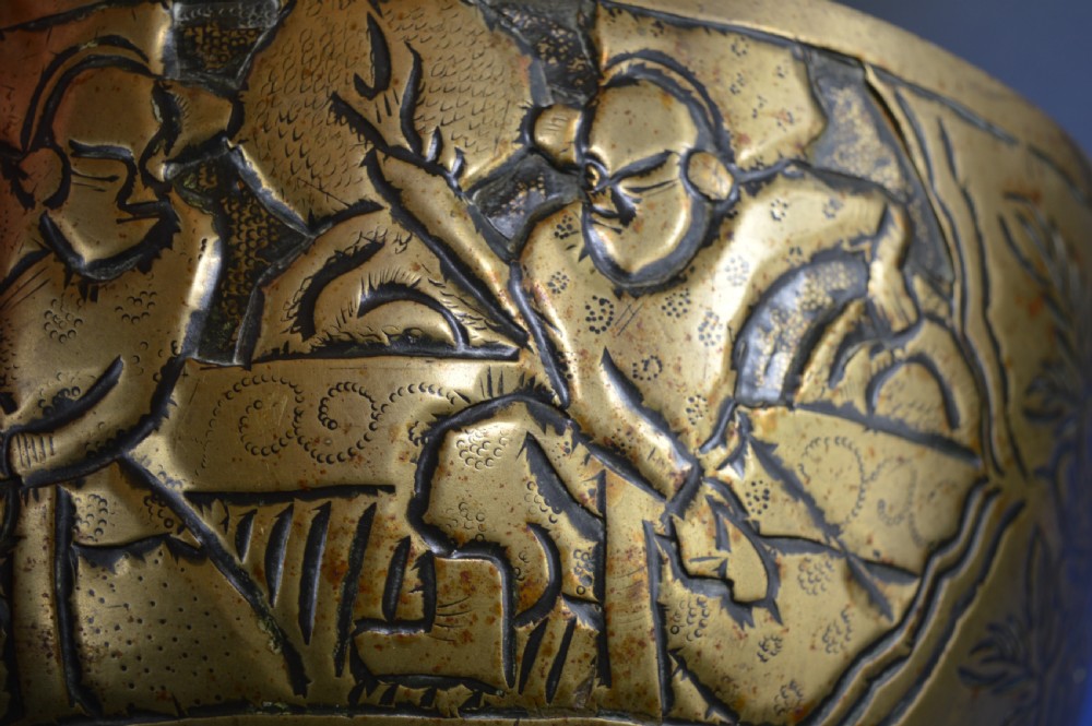 A large circular bronze bowl with relief engravings of figures in a landscape around the exterior and a polished interior. View XI