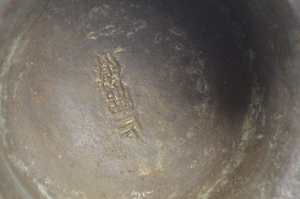 A cast bronze ritual food vessel with two loop handles topped with beast heads, featuring relief carvings and a raised circular base. View VI