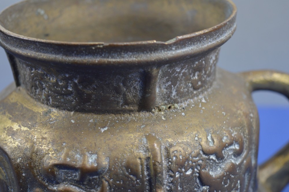 A cast bronze ritual food vessel with two loop handles topped with beast heads, featuring relief carvings and a raised circular base. View VIII