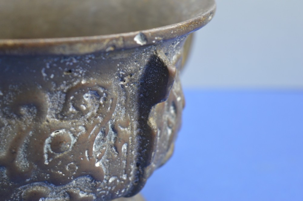 A cast bronze ritual food vessel with two loop handles topped with beast heads, featuring relief carvings and a raised circular base. View XIII