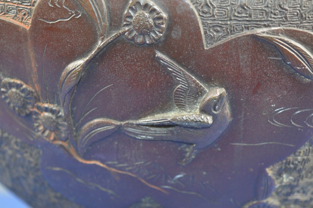 A heavy dark bronze Chinese bowl featuring relief panels with bird and floral motifs, bamboo-style side handles, and a lobed collar over an integral stepped base. View III
