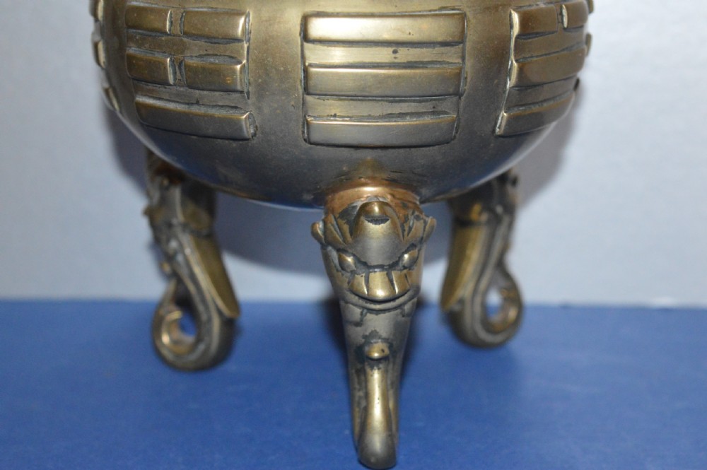 A late nineteenth-century Chinese cast bronze tripod censer featuring raised trigram motifs, upright loop handles, and beast-mask feet. View III