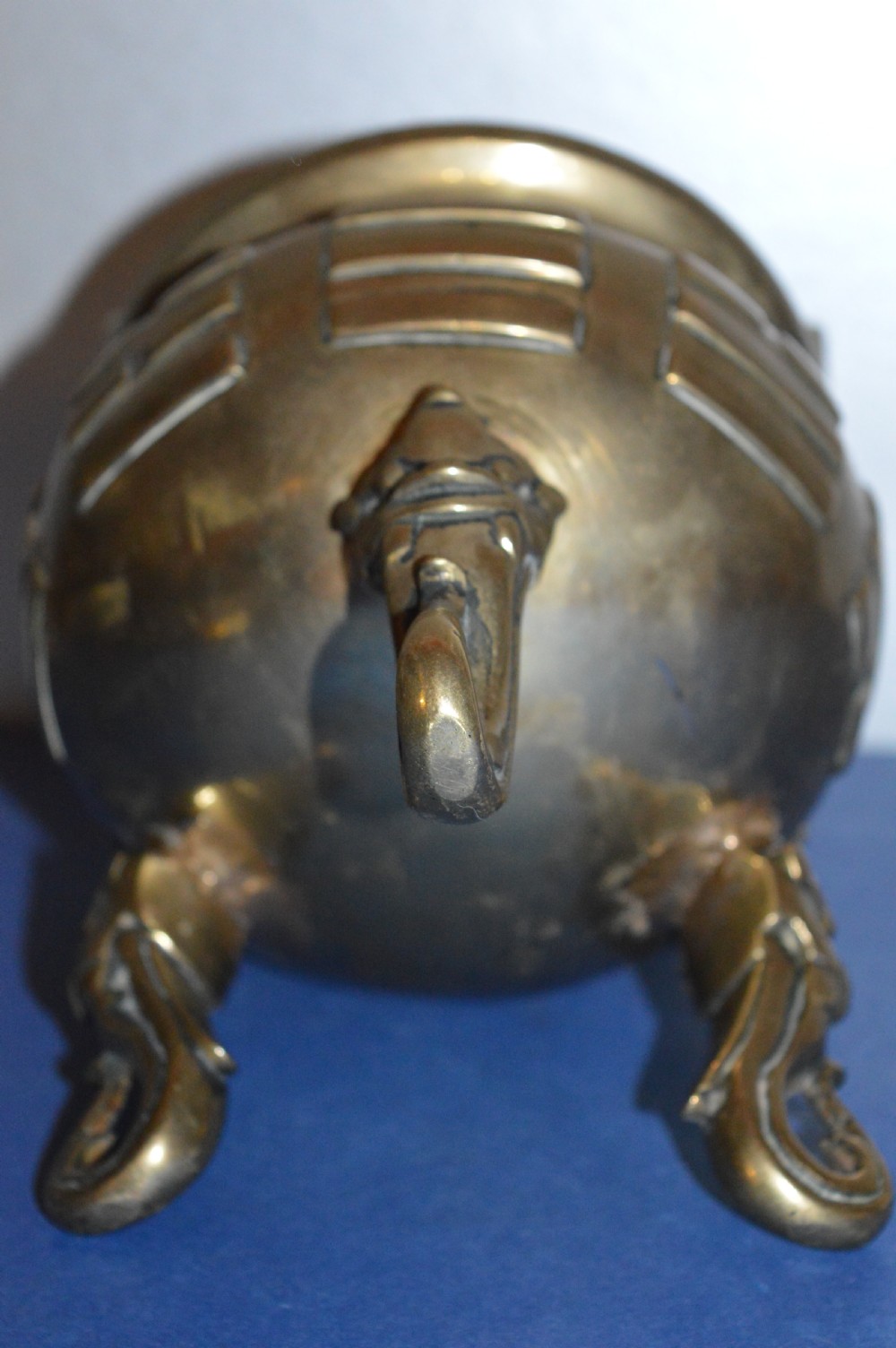 A late nineteenth-century Chinese cast bronze tripod censer featuring raised trigram motifs, upright loop handles, and beast-mask feet. View VII