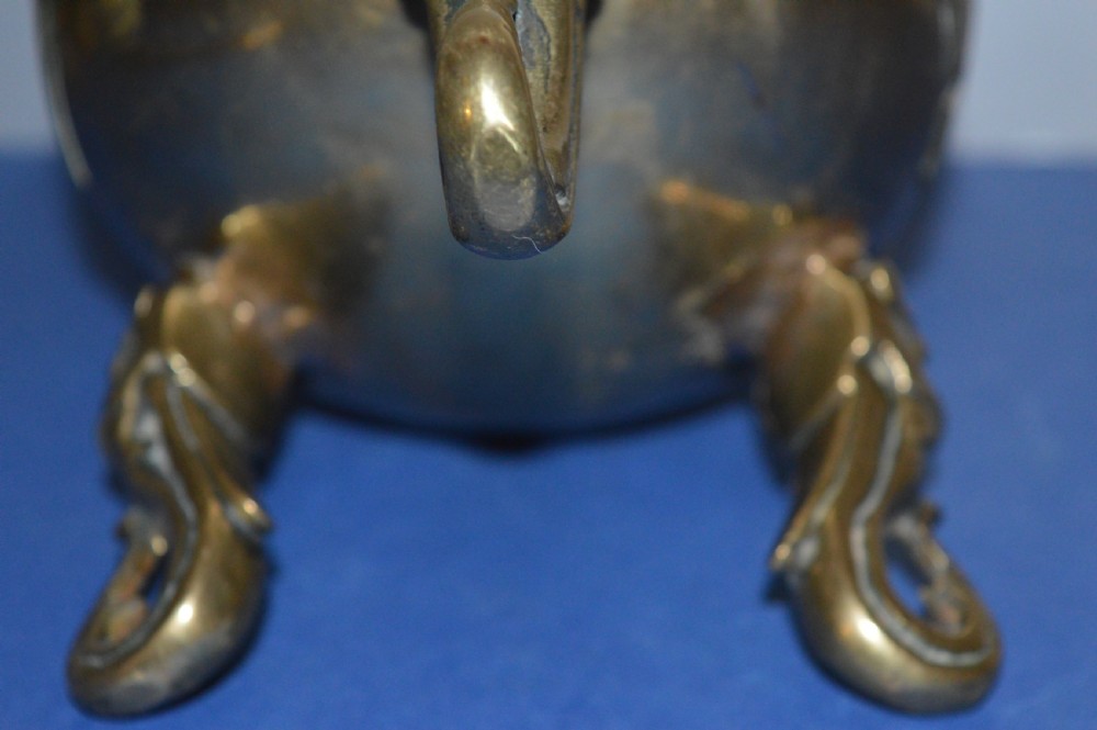A late nineteenth-century Chinese cast bronze tripod censer featuring raised trigram motifs, upright loop handles, and beast-mask feet. View VIII