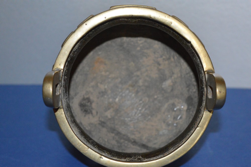 A late nineteenth-century Chinese cast bronze tripod censer featuring raised trigram motifs, upright loop handles, and beast-mask feet. View XI