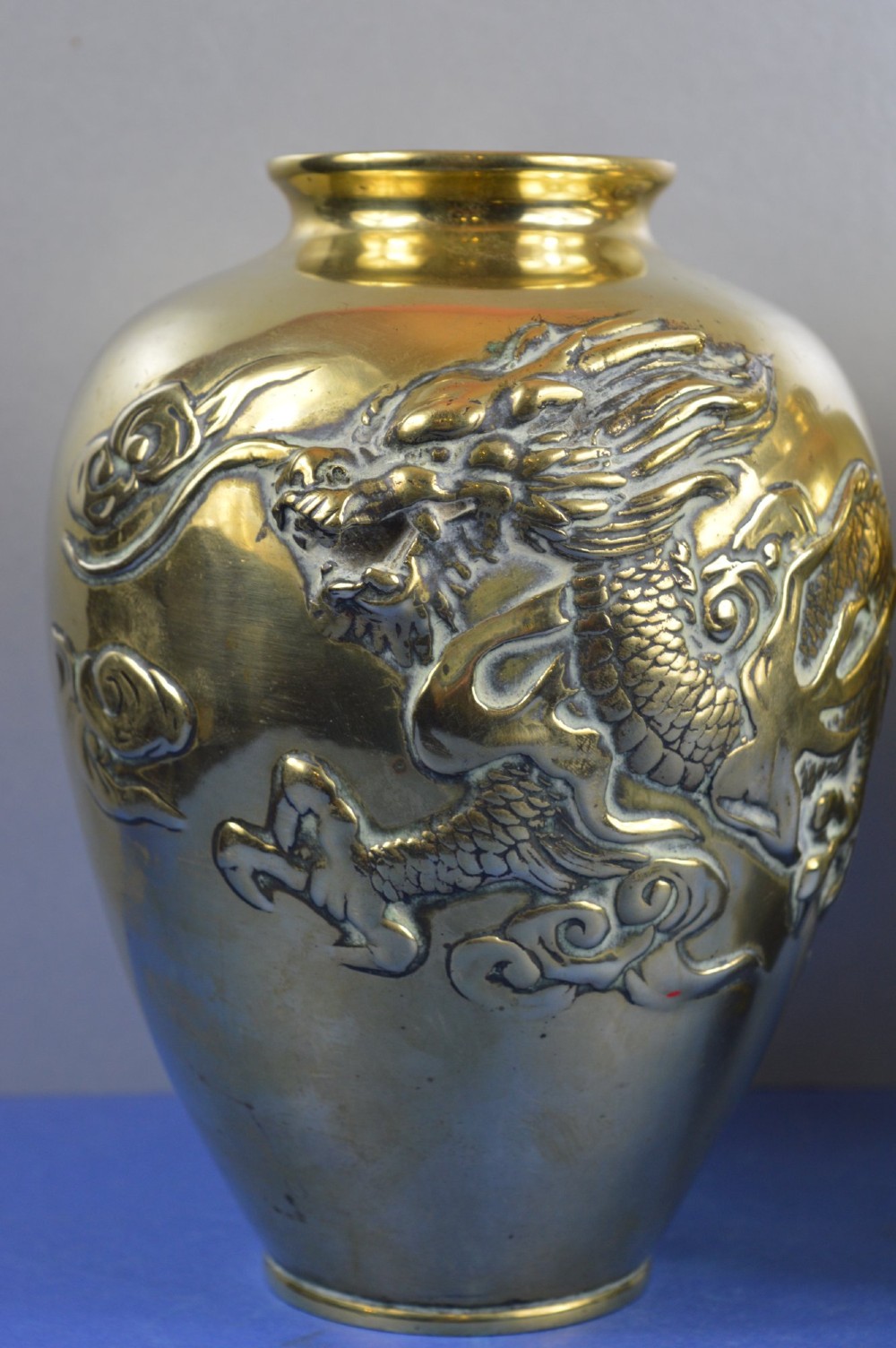 A matching pair of heavy polished gold gilt bronze baluster vases featuring carved high-relief dragons amid swirling cloud motifs. View II