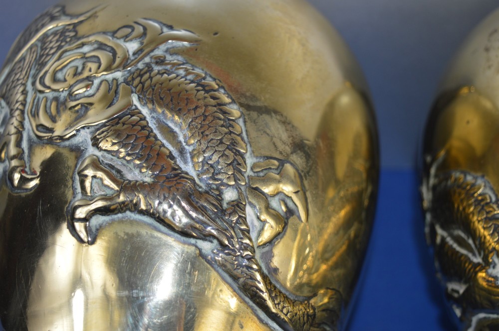 A matching pair of heavy polished gold gilt bronze baluster vases featuring carved high-relief dragons amid swirling cloud motifs. View IX