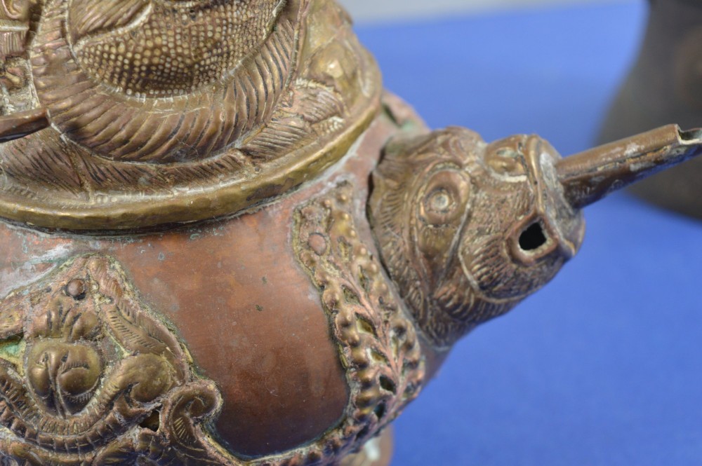 A pair of 19th-century Tibetan metal vessels comprising a squat copper pot with a snow lion lid and a tall cylindrical brass ewer with a dragon spout. View III