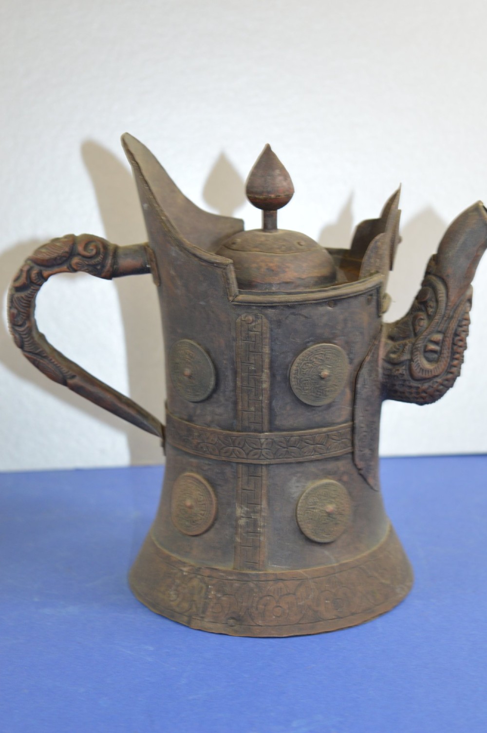 A pair of 19th-century Tibetan metal vessels comprising a squat copper pot with a snow lion lid and a tall cylindrical brass ewer with a dragon spout. View VI