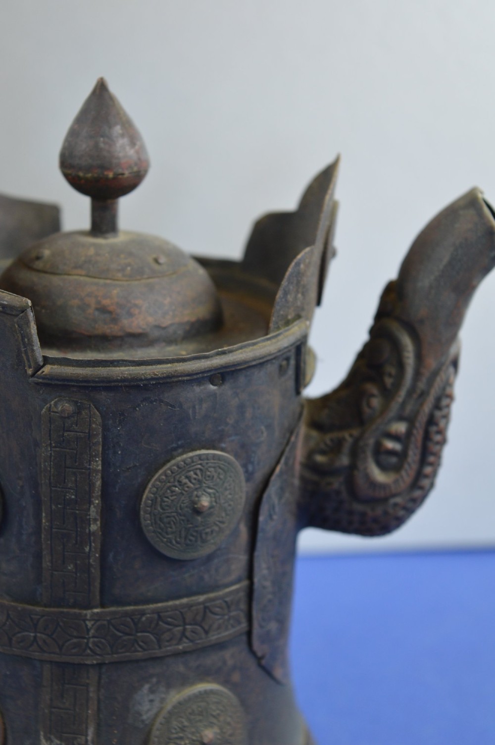 A pair of 19th-century Tibetan metal vessels comprising a squat copper pot with a snow lion lid and a tall cylindrical brass ewer with a dragon spout. View VII