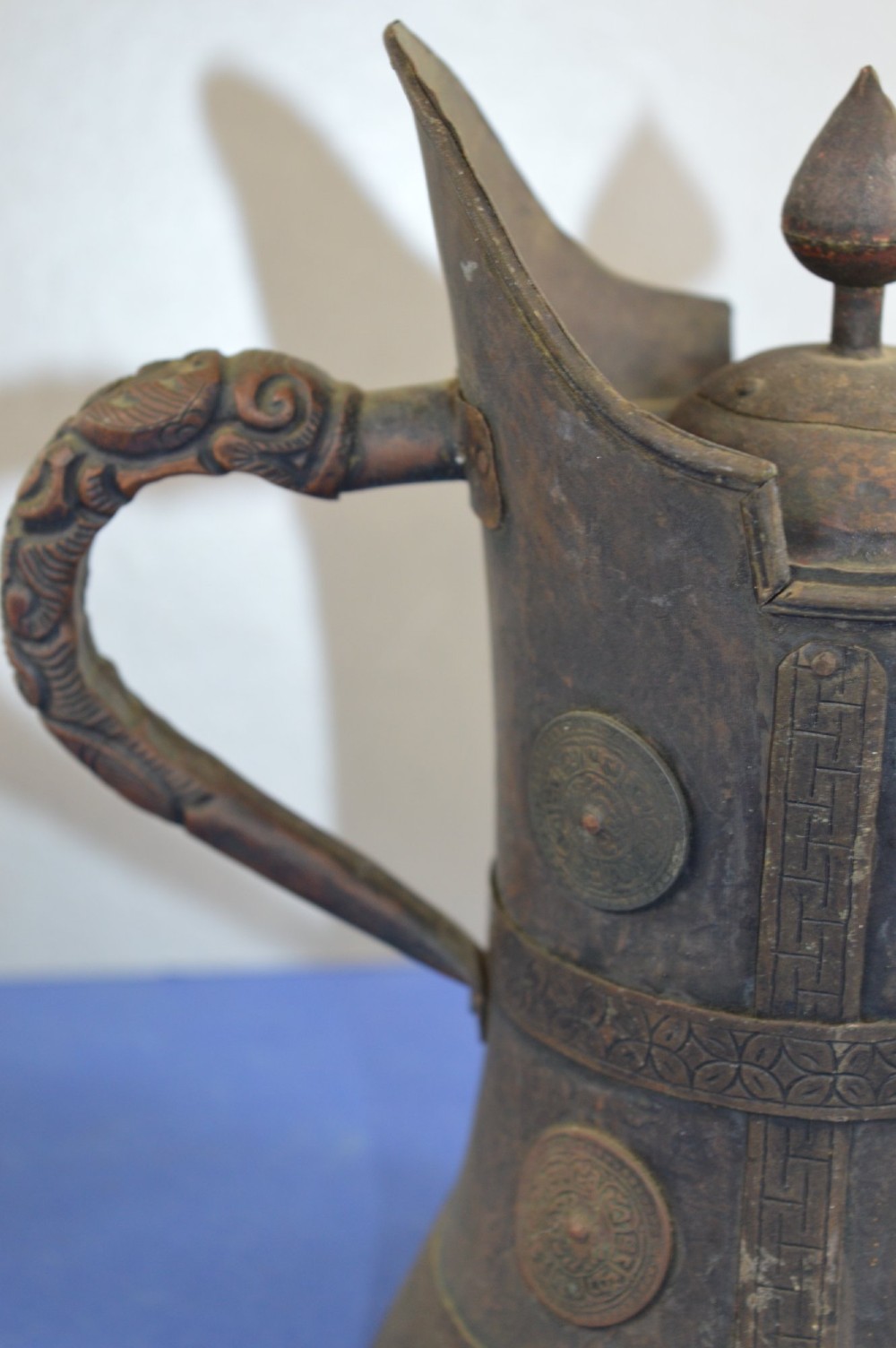 A pair of 19th-century Tibetan metal vessels comprising a squat copper pot with a snow lion lid and a tall cylindrical brass ewer with a dragon spout. View IX