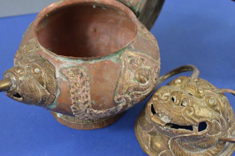 A pair of 19th-century Tibetan metal vessels comprising a squat copper pot with a snow lion lid and a tall cylindrical brass ewer with a dragon spout. View XI