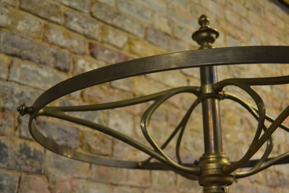 A freestanding Victorian coat stand featuring a circular brass hat rack crown, a central brass stem, and a heavy four-legged cast iron base. View IV