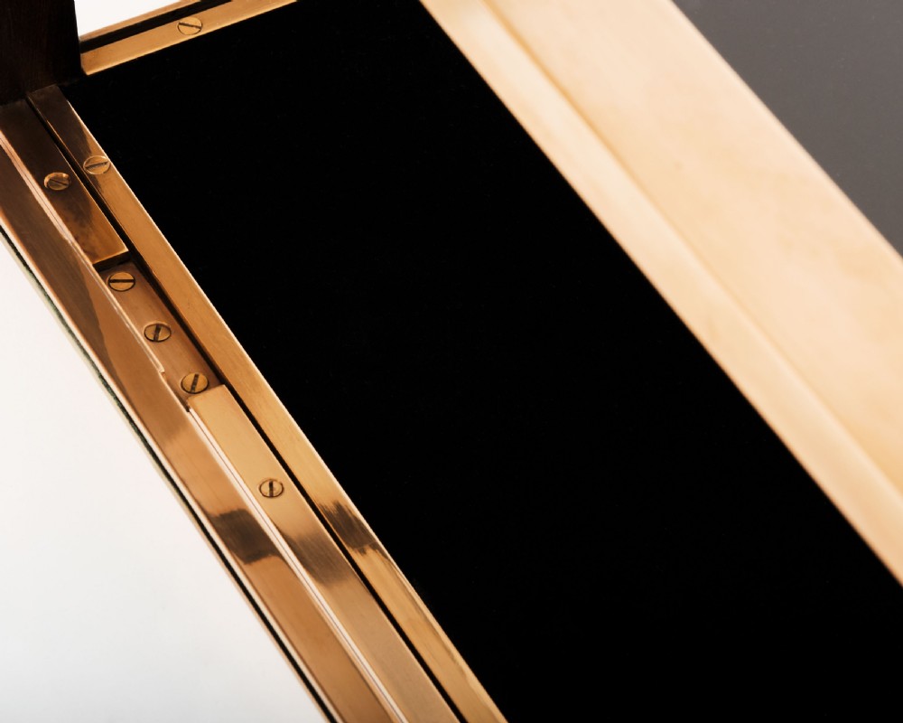 A rectangular clear glass display case with a brass frame and a black velvet-lined bottom surface. View IV