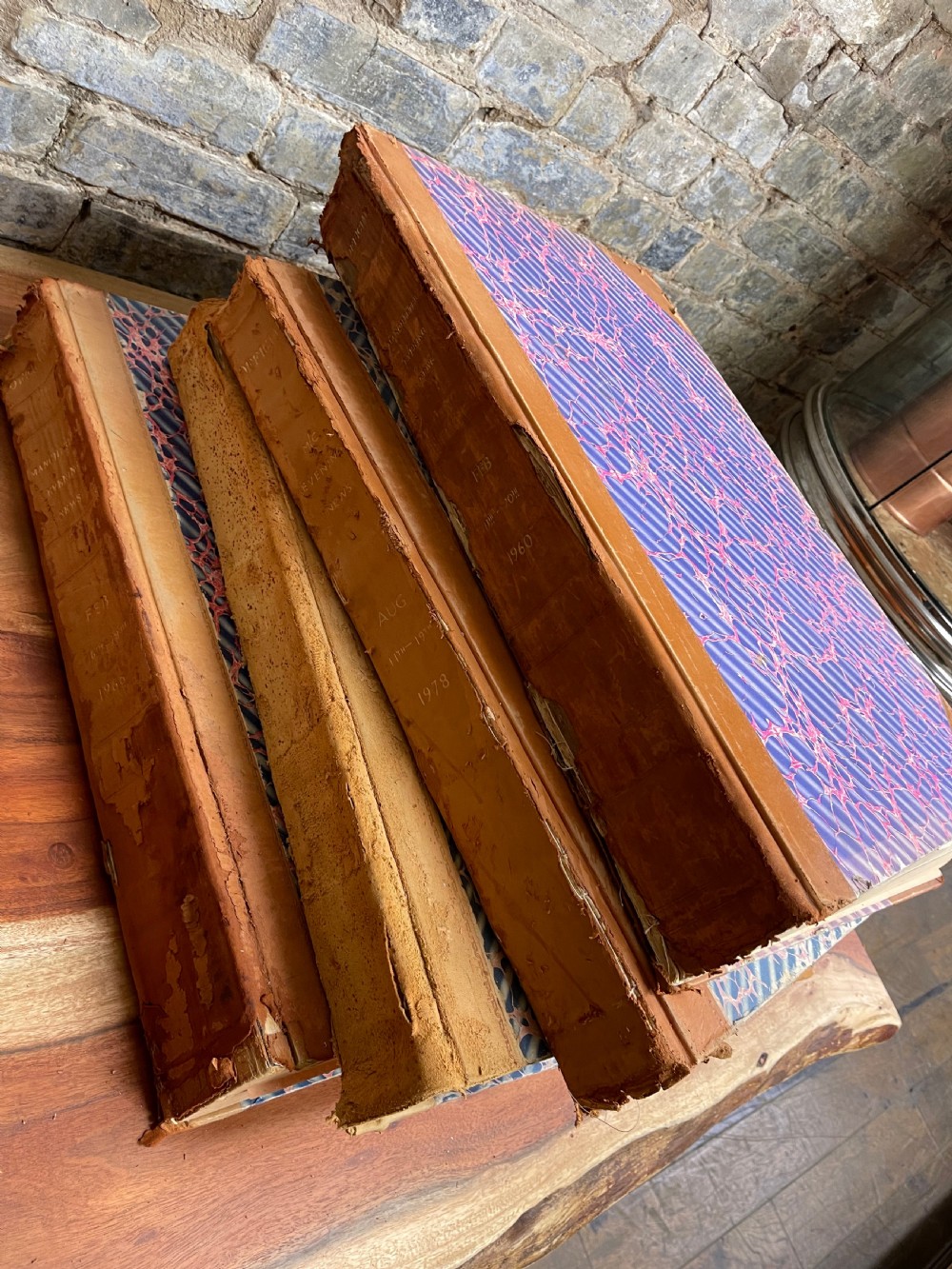 A large mid-20th-century bound archive volume of the Manchester Evening News featuring a tan leather spine with gilt lettering and marbled paper covers. View V