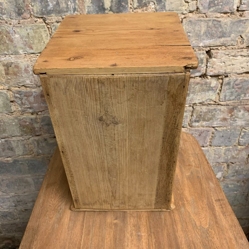 A small tabletop pine cabinet with four stacked drawers, each fitted with a round brass knob. View VII