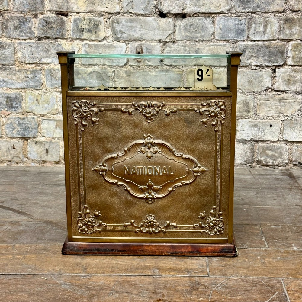 An ornate antique brass National cash register featuring a marble shelf, glass indicator top, and detailed relief scrolls. View IV