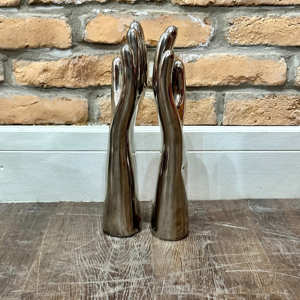 A pair of polished silver aluminium hand-shaped glove moulds standing vertically on flat bases. View IV