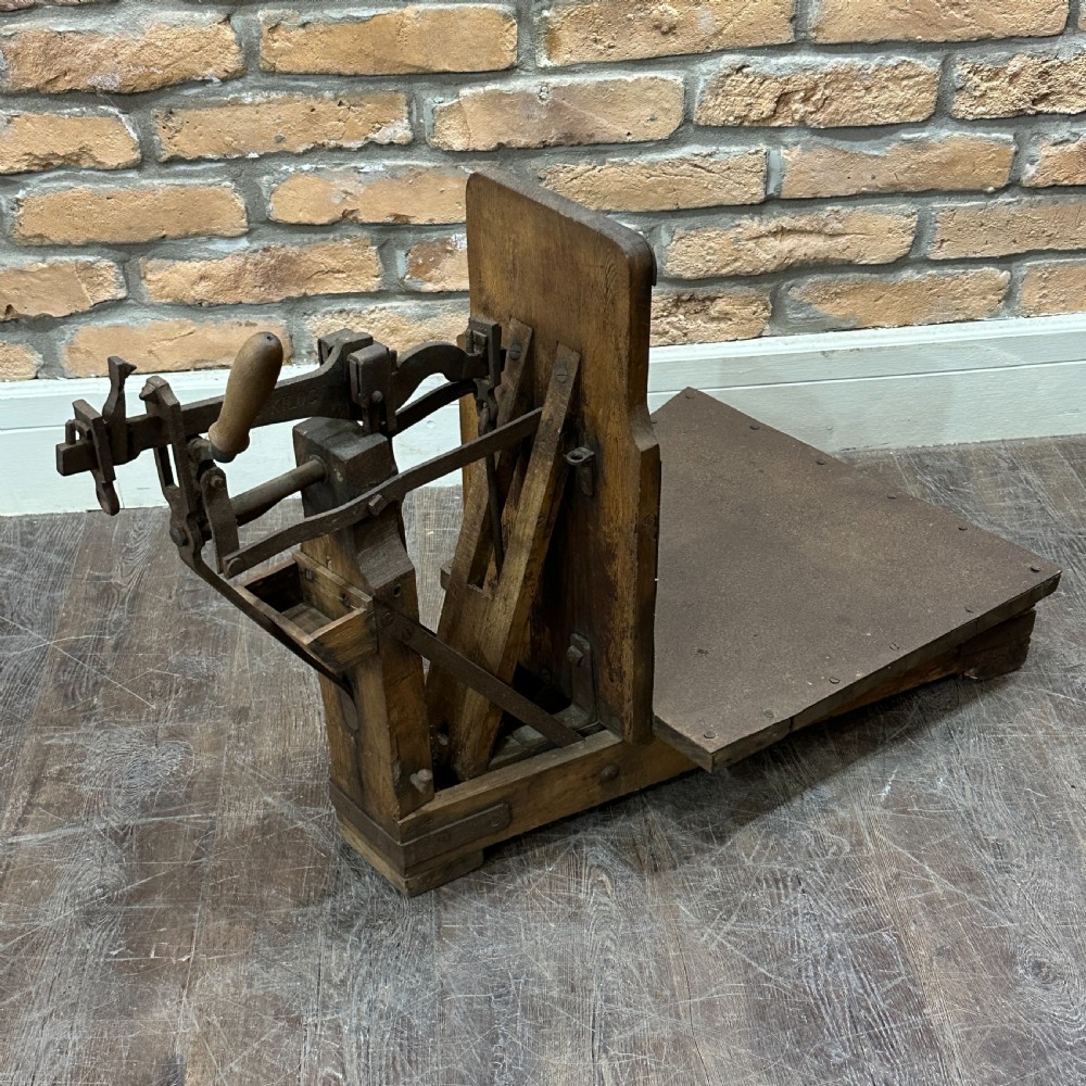 An antique floor platform scale featuring a wooden base, metal platform, and an exposed cast iron mechanical weighing arm. View VI
