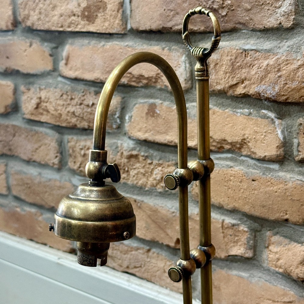 A vintage brass swan neck desk lamp featuring an adjustable curved arm, stepped circular base, and turned fitting details. View III