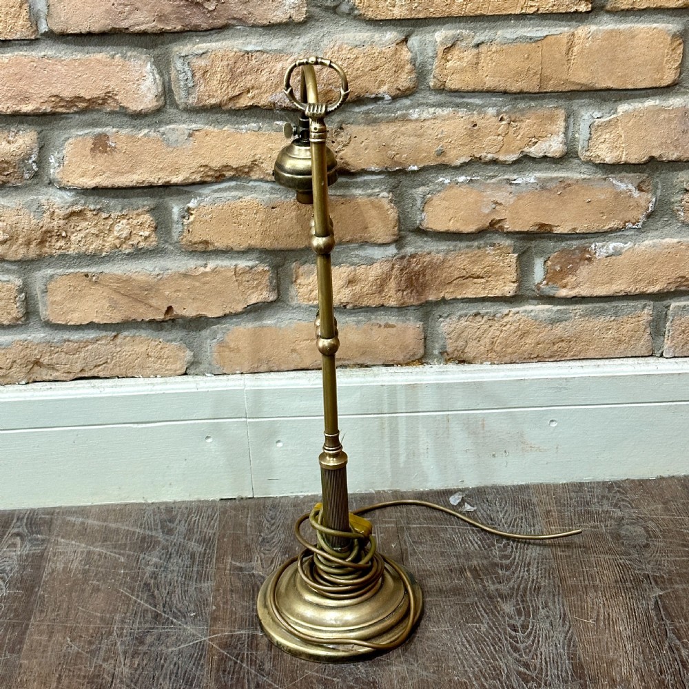 A vintage brass swan neck desk lamp featuring an adjustable curved arm, stepped circular base, and turned fitting details. View V