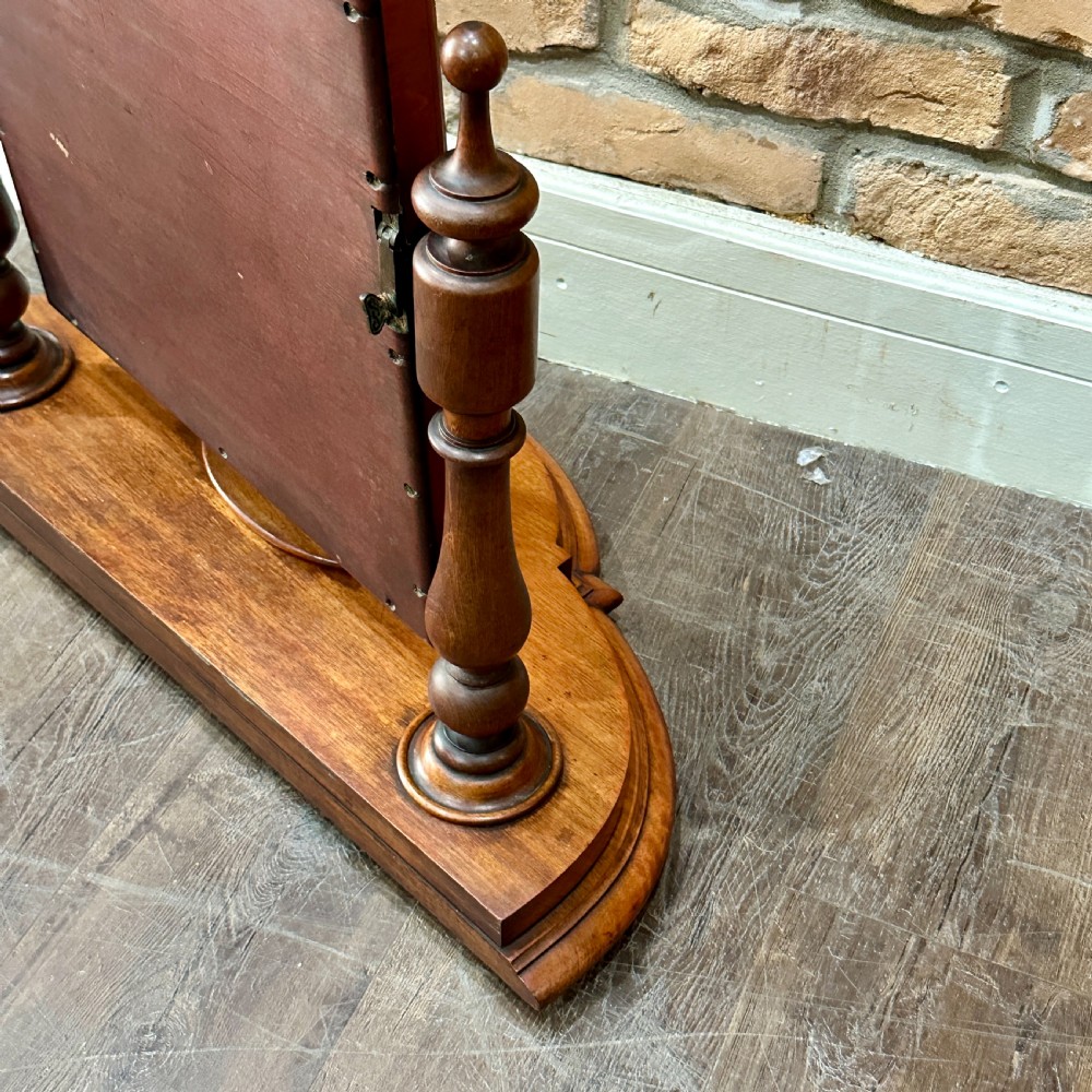 A Victorian mahogany swivel toilet mirror with turned side columns and a sculpted plinth base featuring an oval tray. View VI