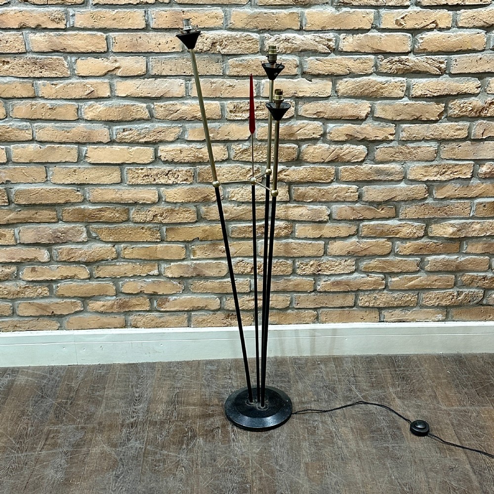A mid-century French modernist floor lamp featuring three angled black and brass stems terminating in cone-shaped socket holders set upon a circular base.