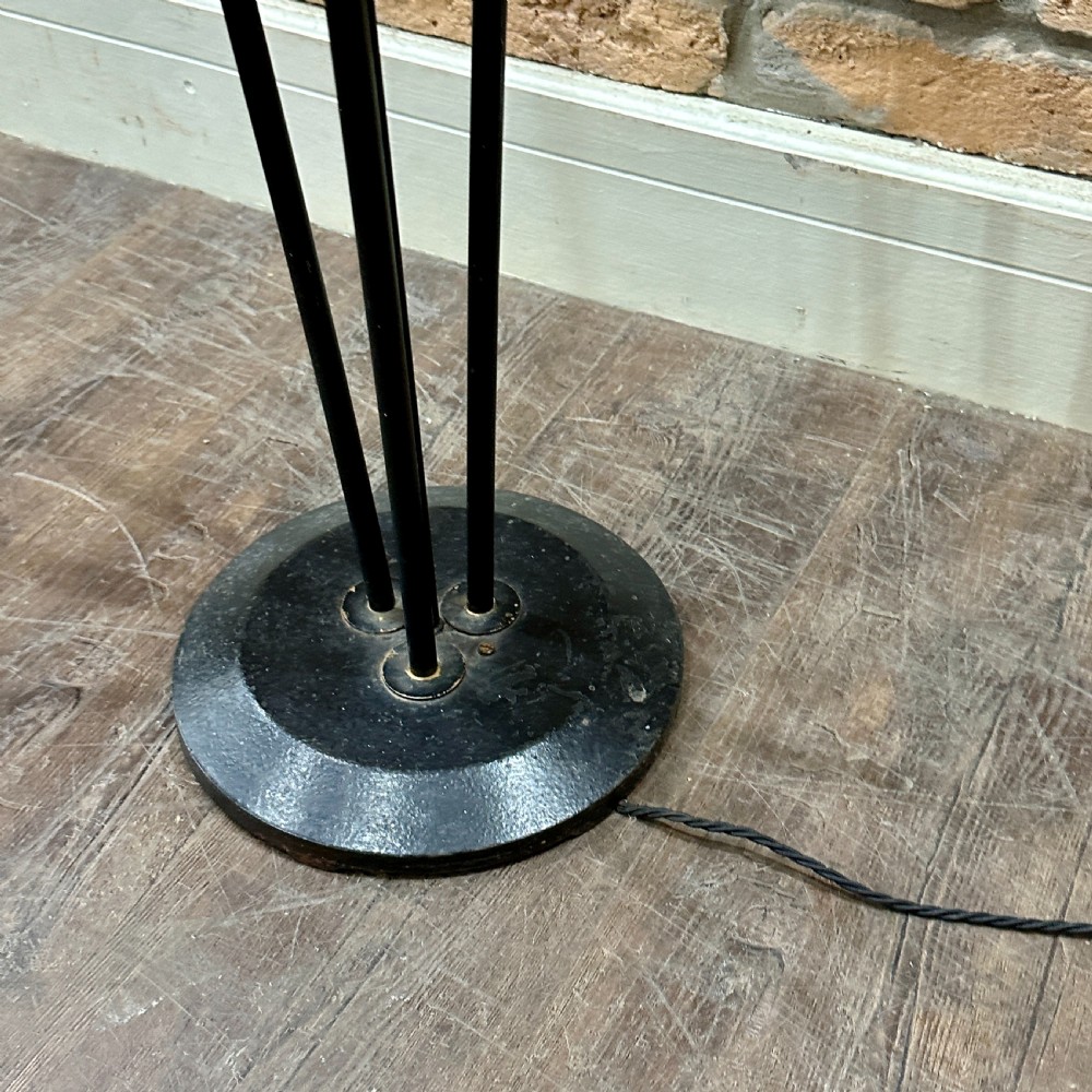 A mid-century French modernist floor lamp featuring three angled black and brass stems terminating in cone-shaped socket holders set upon a circular base. View IV