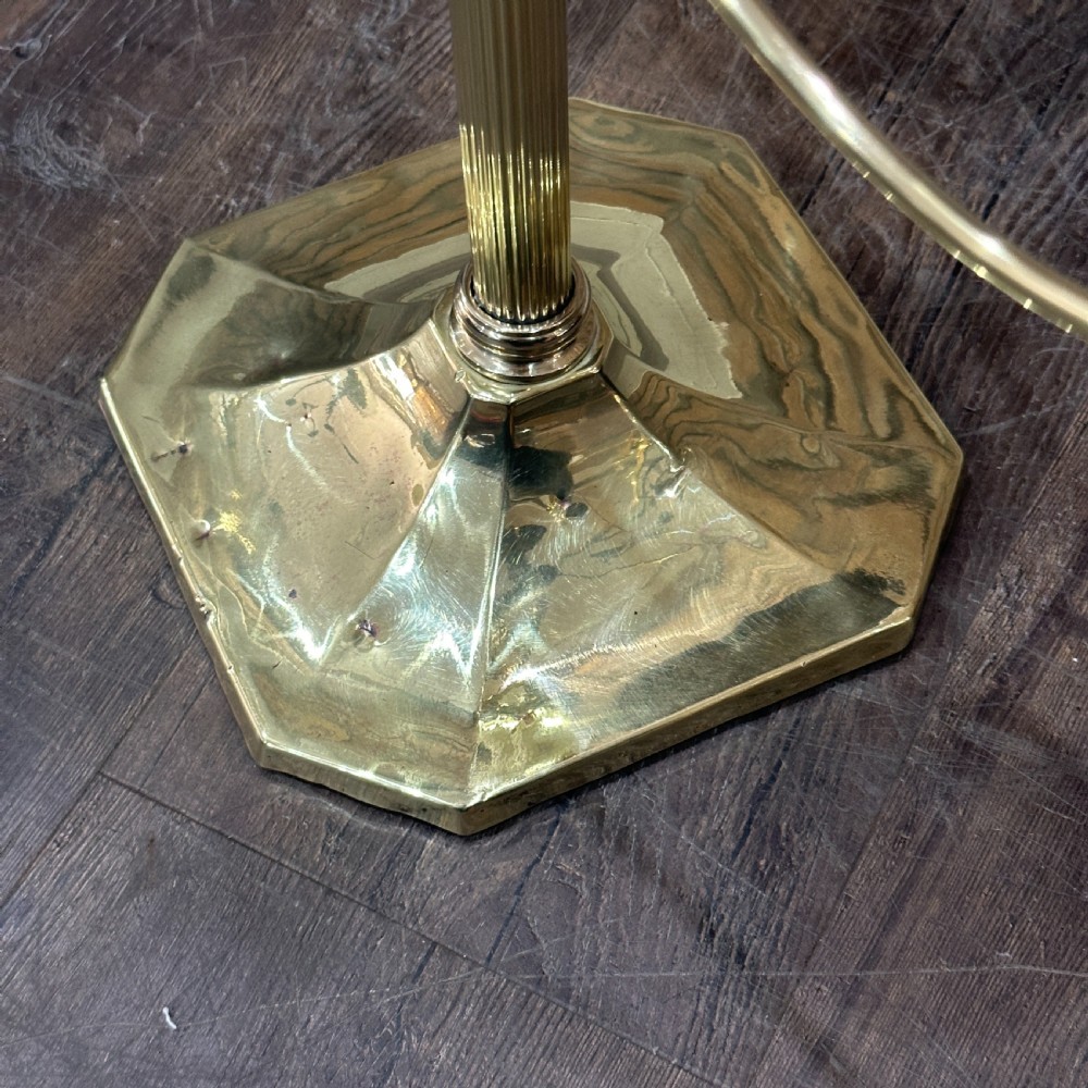 A polished brass multi-arm countertop hat stand featuring a reeded central column, six curved display arms, and a weighted octagonal base. View VI