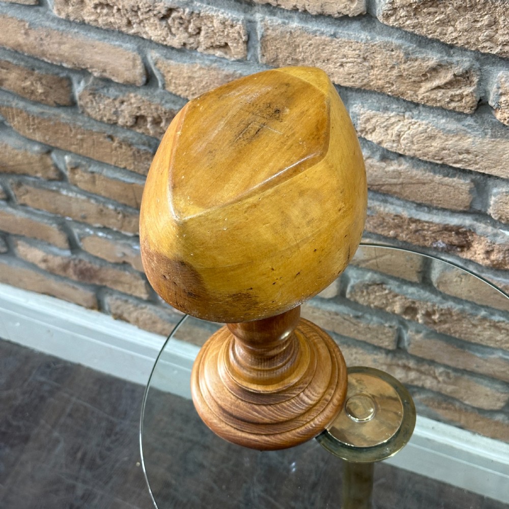 A solid turned beechwood hat block mounted on a turned pedestal and circular stepped base. View III