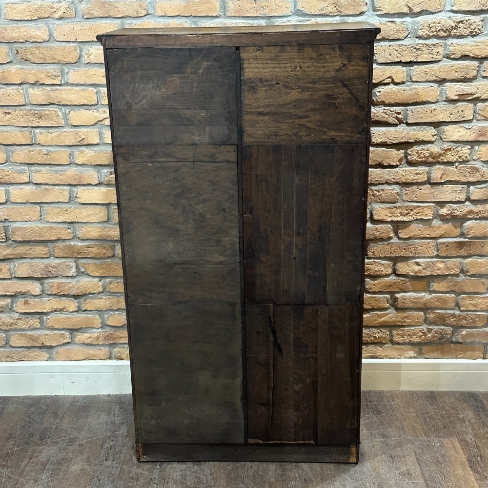 A vintage 1930s oak school cabinet featuring two doors with hand-painted institutional lettering and a crest. View IV