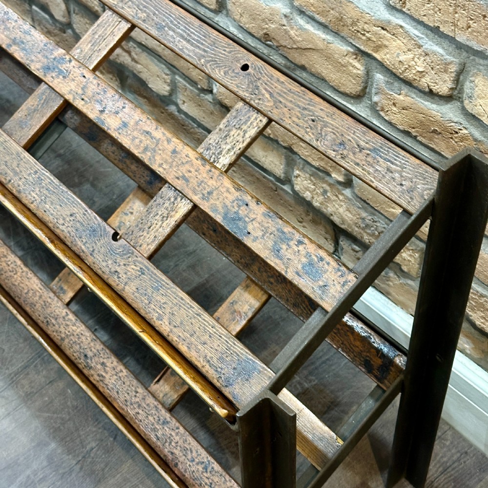 A two-tier vintage shop display counter featuring slatted oak shelves set within a dark metal frame with bronze detailing. View II