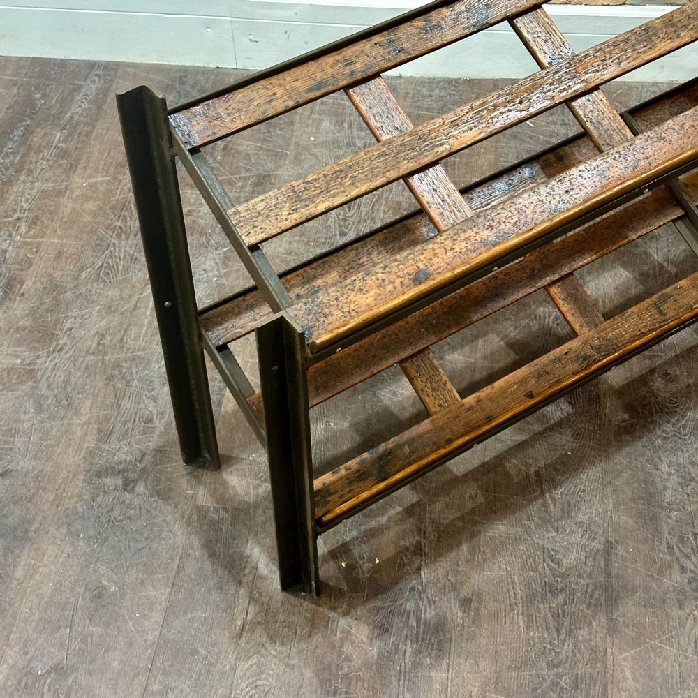 A two-tier vintage shop display counter featuring slatted oak shelves set within a dark metal frame with bronze detailing. View V