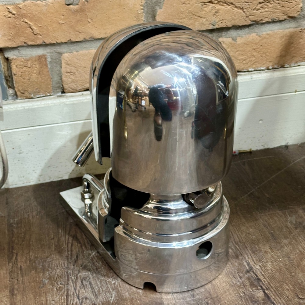 A restored 1930s polished aluminium mechanical hat stretcher with a turn handle set on a solid metal base. View IV