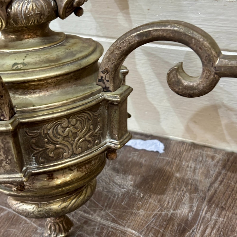A pair of ornate cast brass twin-arm wall sconces featuring sculpted cherub heads and decorative scrolling branches. View V