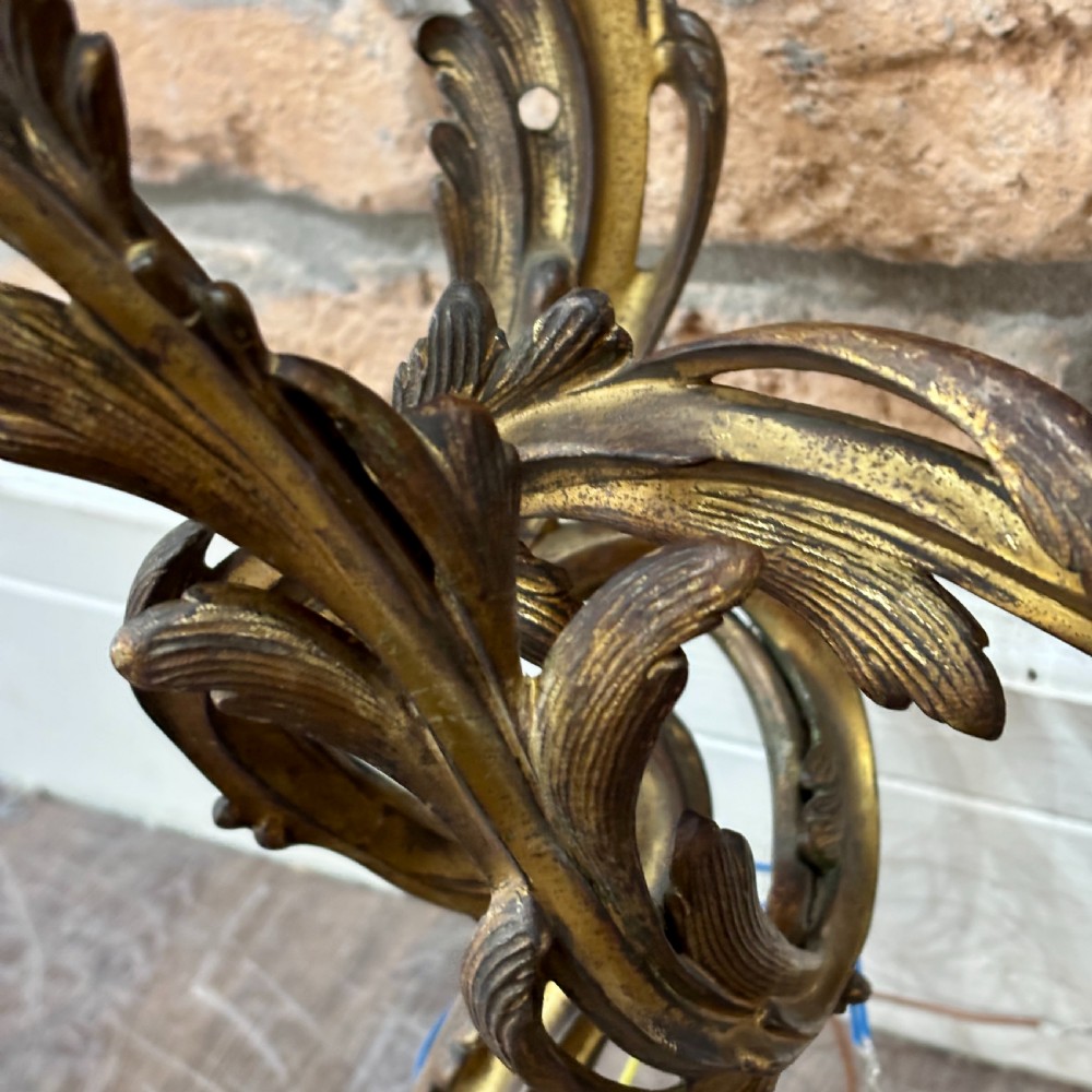 A pair of gilt brass two-arm wall sconces featuring ornate Rococo scrollwork and acanthus leaf decoration. View IV