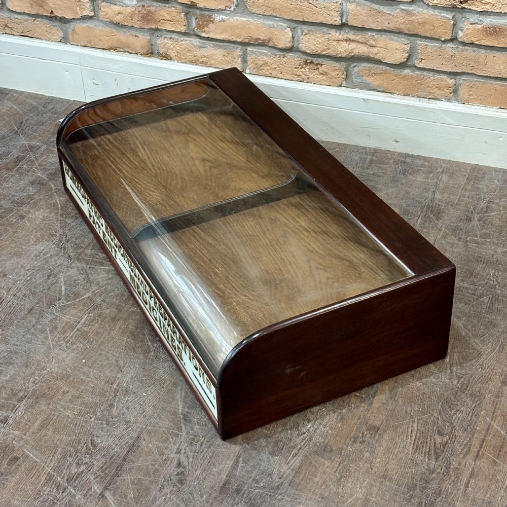 A Victorian mahogany countertop display cabinet featuring a curved glass front and a lower white panel reading Homoeopathic Medicines and Preparations. View IV