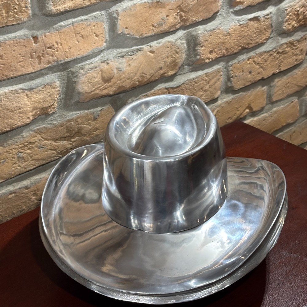 A polished silver aluminium milliners hat block mould shaped in a fedora brim silhouette. View III