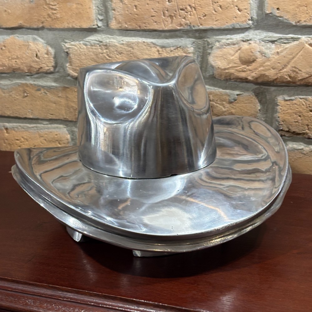 A polished silver aluminium milliners hat block mould shaped in a fedora brim silhouette. View IV