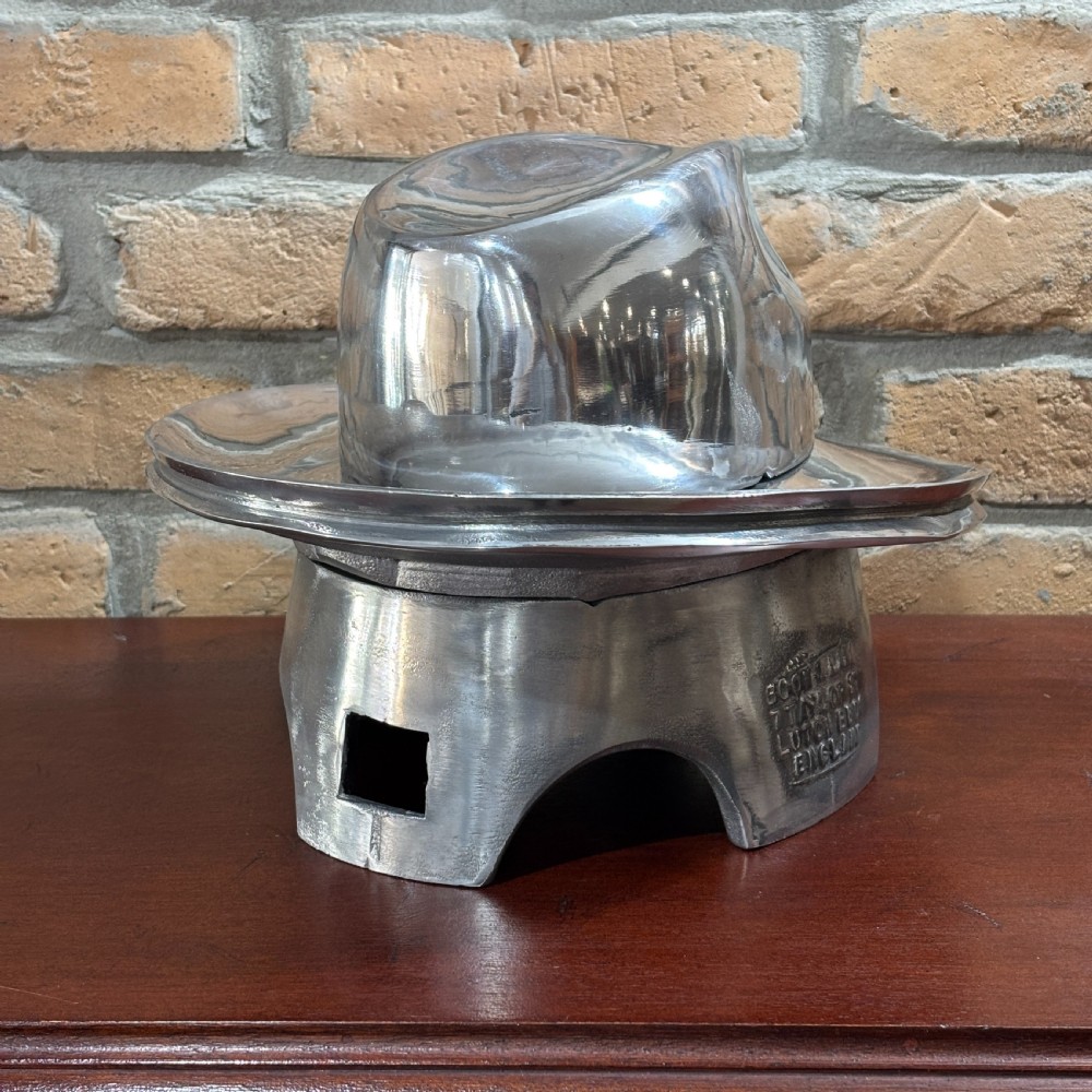 A polished silver aluminium two-piece milliners hat block mould stamped with maker details.