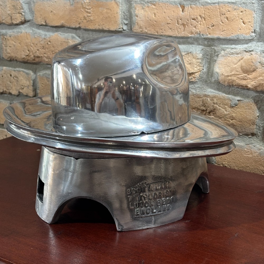 A polished silver aluminium two-piece milliners hat block mould stamped with maker details. View II