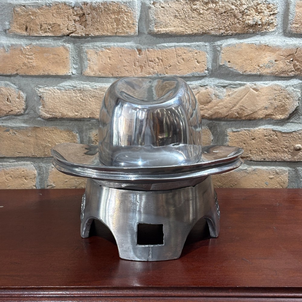 A polished silver aluminium two-piece milliners hat block mould stamped with maker details. View IV