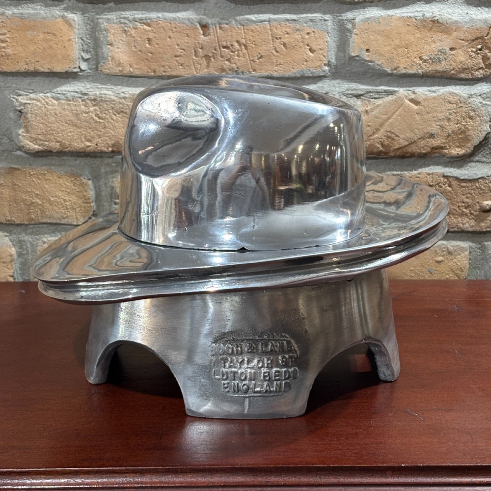 A polished silver aluminium two-piece milliners hat block mould stamped with maker details. View V