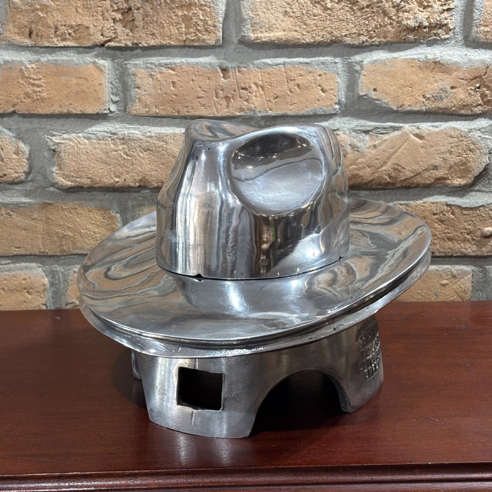 A polished silver aluminium two-piece milliners hat block mould stamped with maker details. View VI